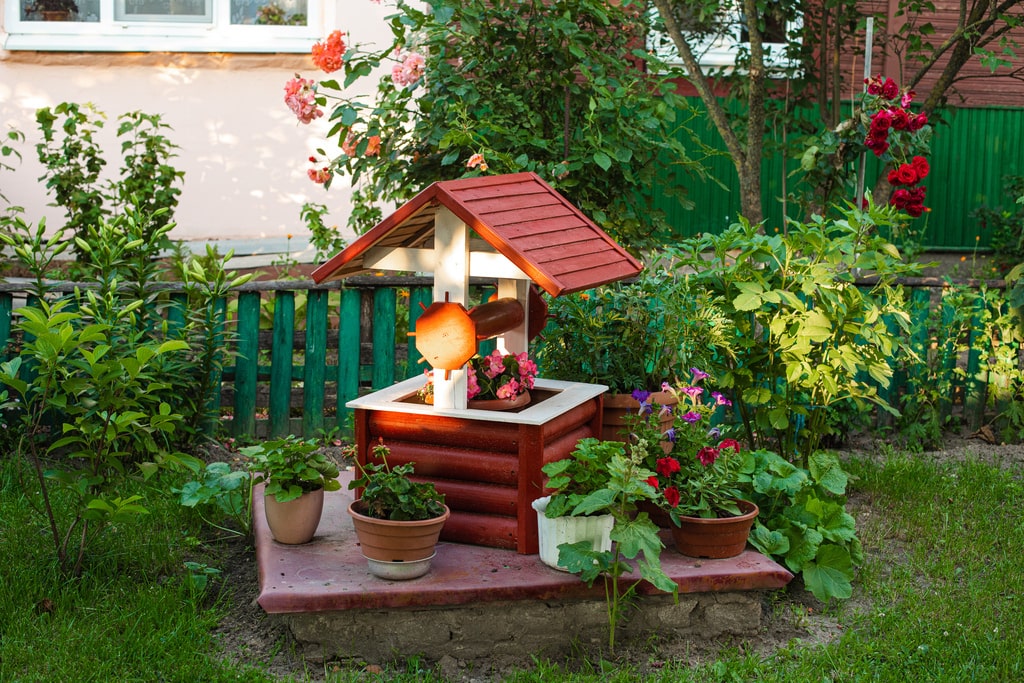 Nella cura del giardino in estate vanno presi diversi accorgimenti: il terreno e più fragile, il sole disidrata il terreno, e bisogna porre molta attenzione nelle operazioni di innaffiatura e potatura. Nella foto un ornamento da giardino con candele.